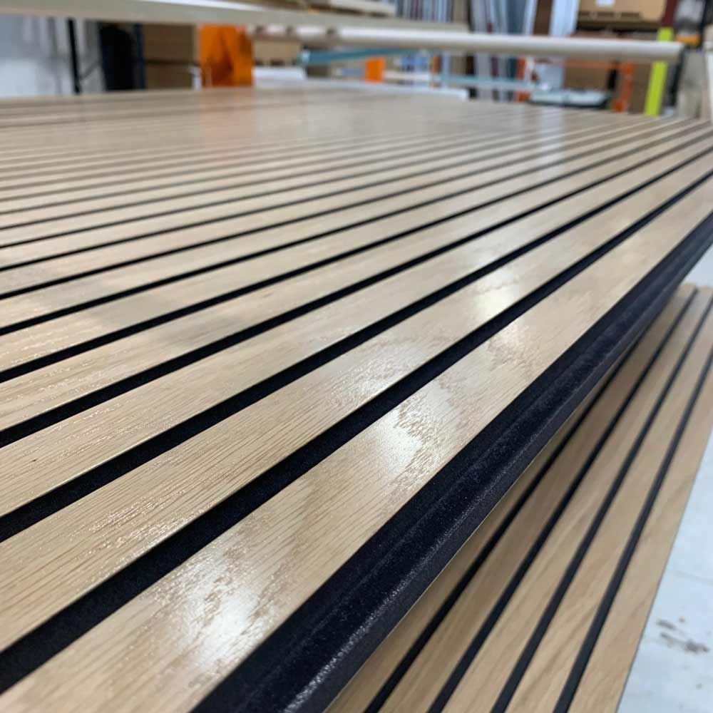 oake veneered black mdf slat wall panels with a water based lacquer applied to panels in a workshop