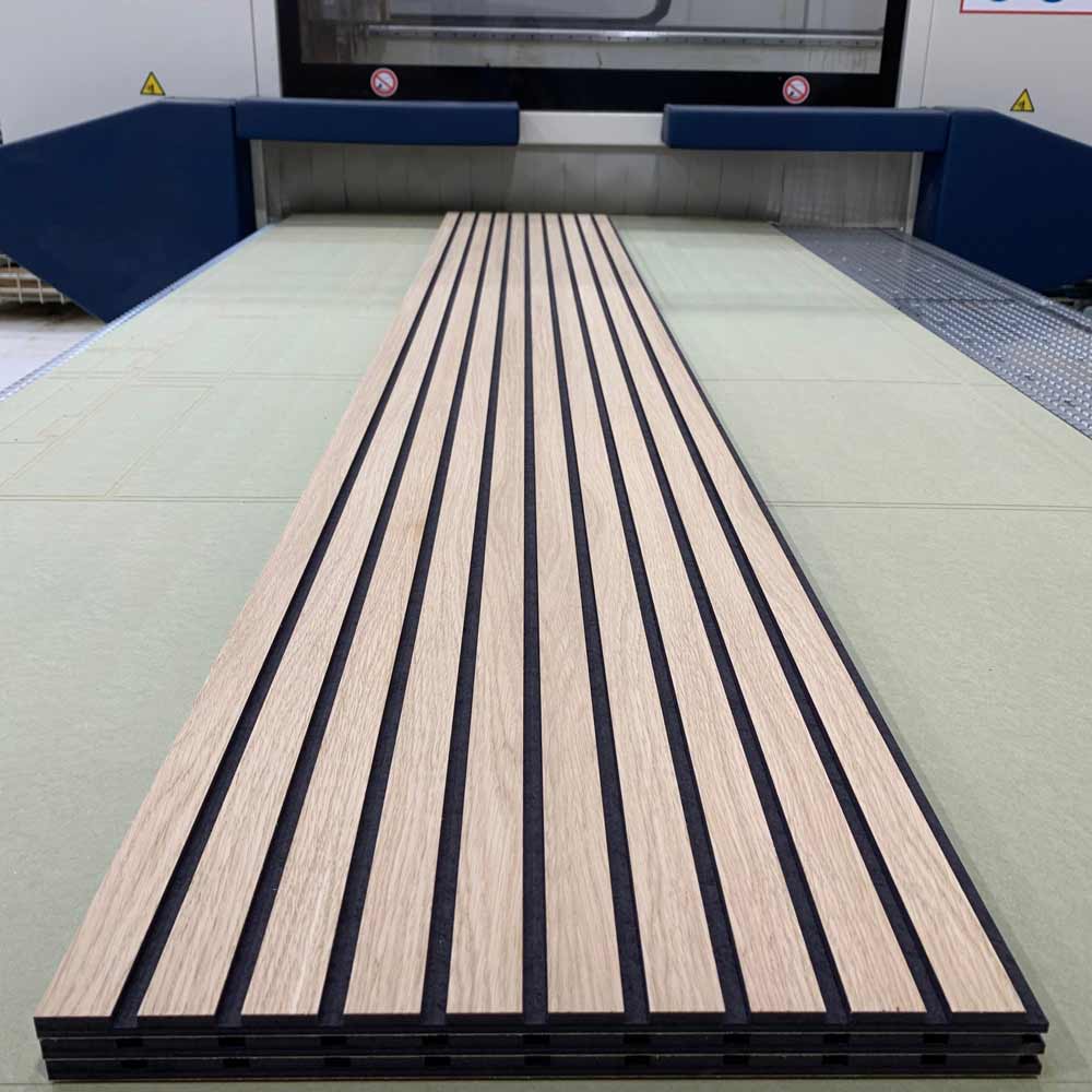 three lengths of 2400 x 390 oak veneer slat wall panels laid on top of each other on a cnc machine