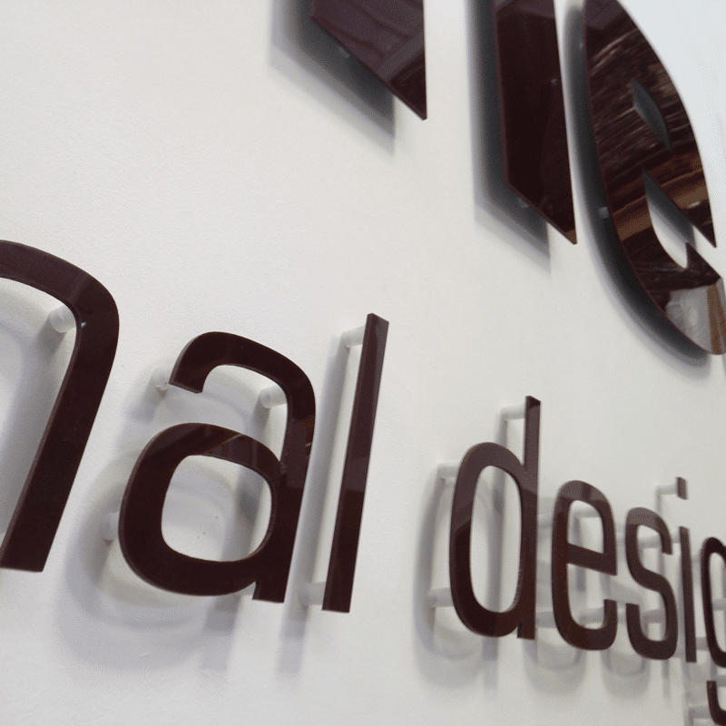 Brown cnc acrylic letters cut to shape and fitted to a wall with standoffs