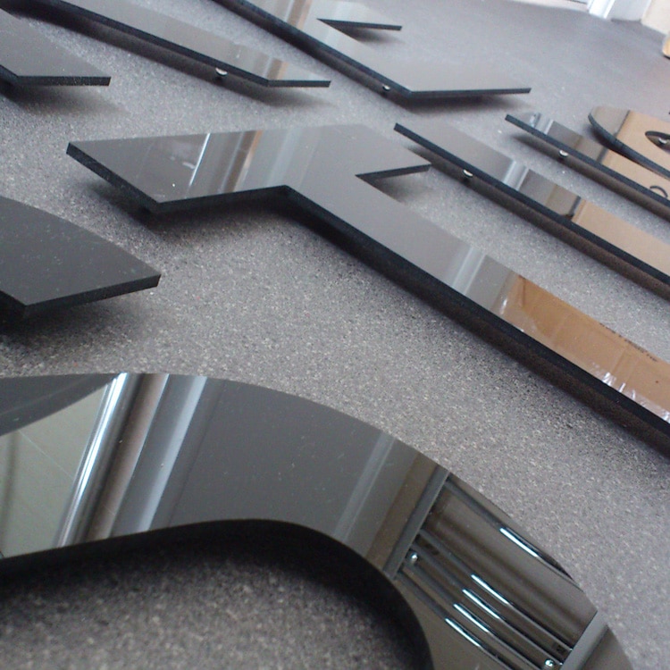 A close up photo of CNC cut black acrylic letters mounted on standoffs