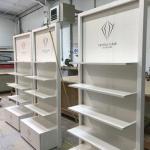 Three white laminated bespoke FSDU's sitting in a workshop awaiting deliver to the customer