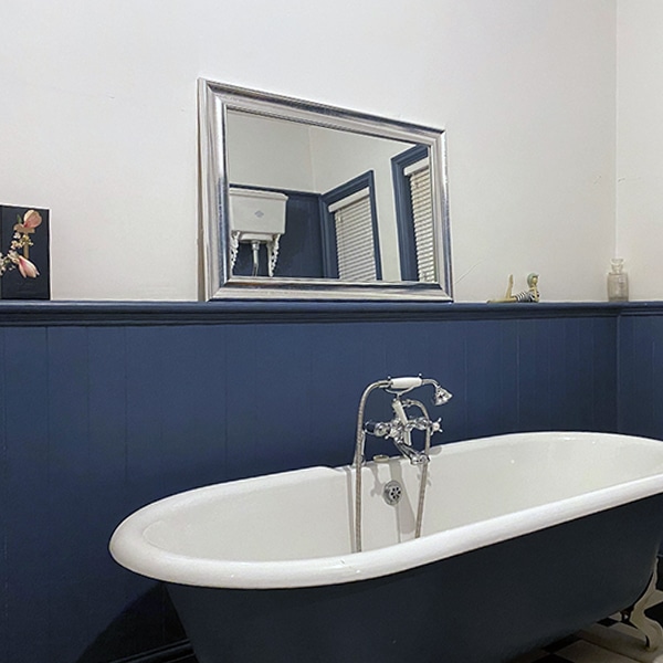 Painted blue bead and butt panels in a bathroom with a freestanding roll-top bath
