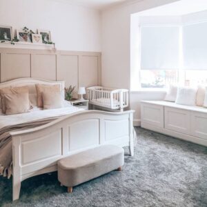 a bed sat in front of beige wall panelling in a neutral themed bedroom