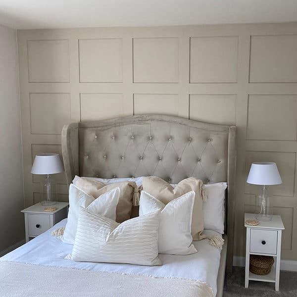 a photo of a taupe coloured bedroom with shaker style wall panelling