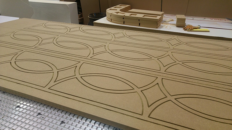 CNC fret cut MDF screen panels sitting on a CNC router bed