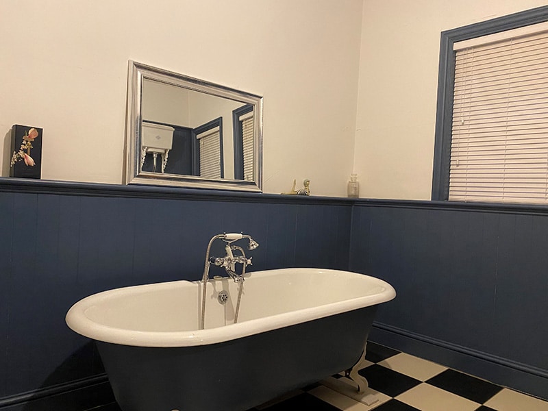 A Victorian bathroom with blue painted MDF V-Groove wall cladding and dado rail