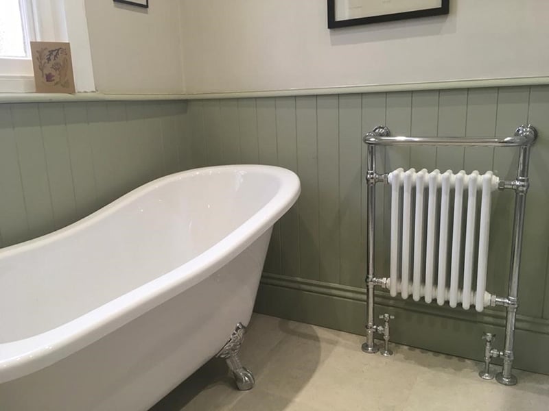 Green painted V-groove MDF wall paneling in a Victorian bathroom