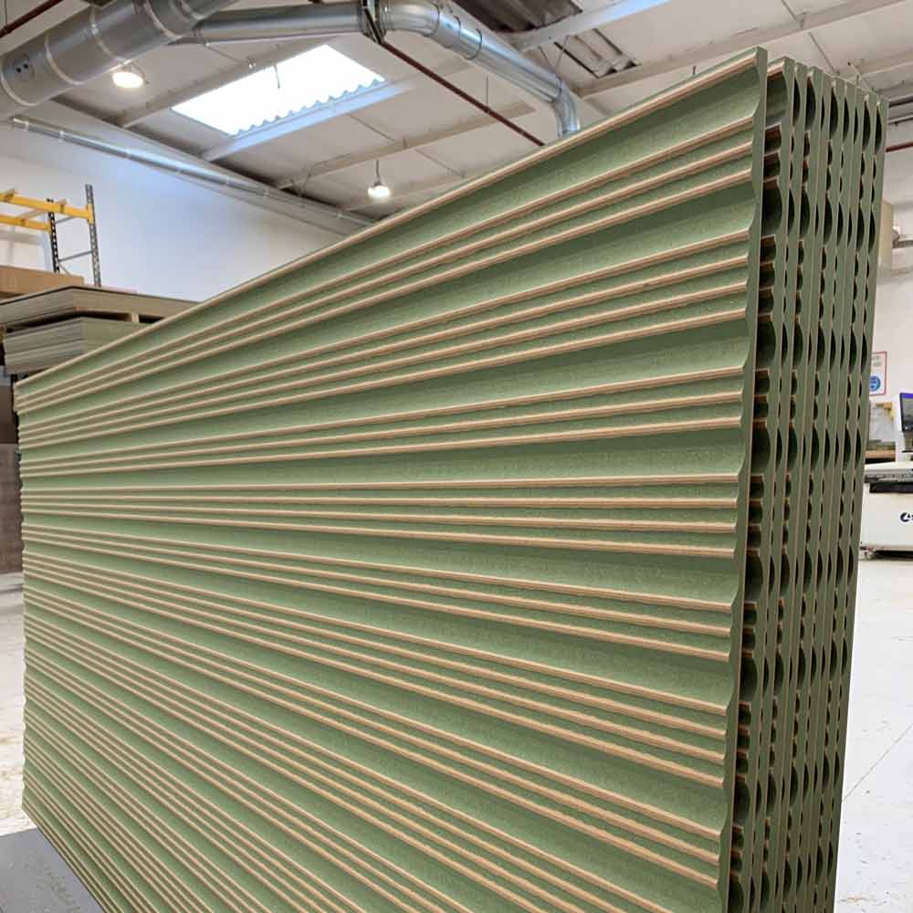 bespoke cut fluted panels stacked in a workshop
