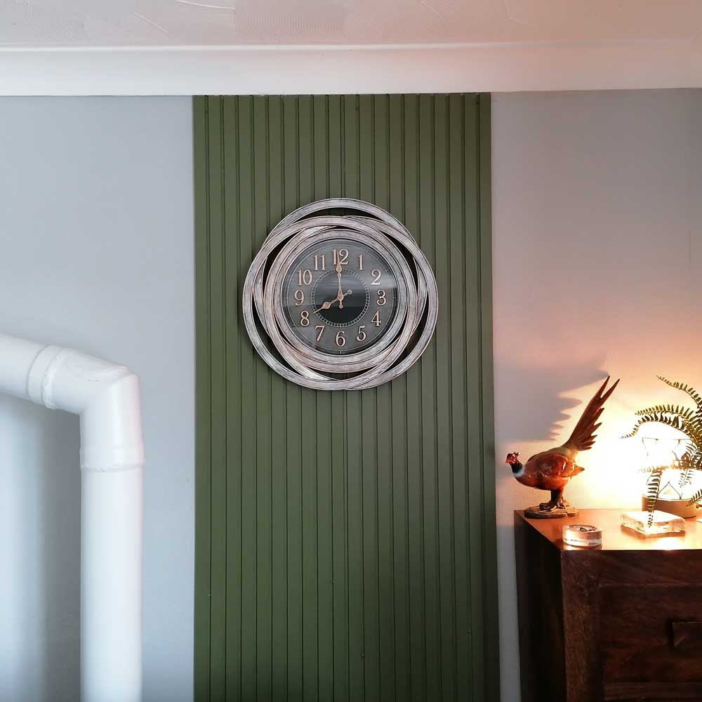mdf slat wall panelling painted in green in the centre of the wall with a clock in the middle of the panelling