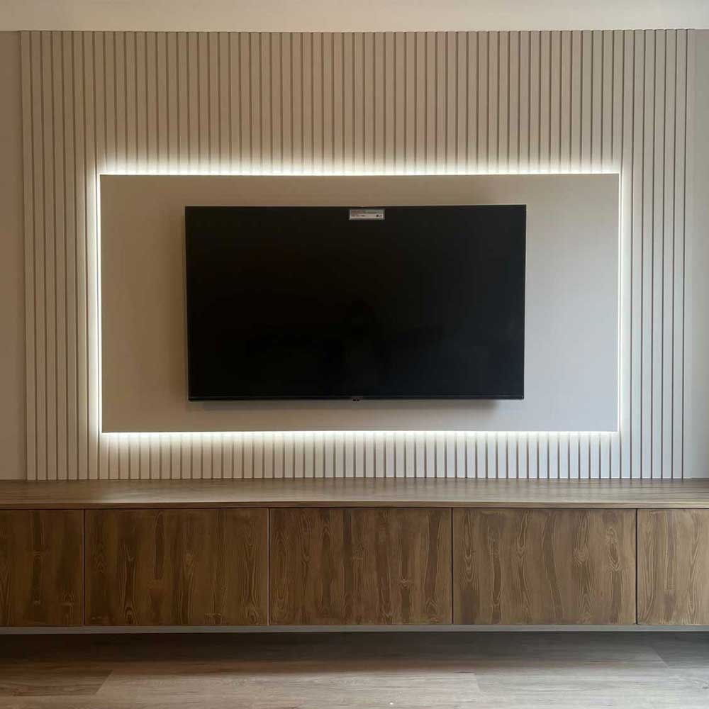 mdf slat wall painted in cream behind a bespoke tv media unit with led lighting